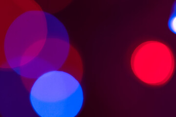 Blue and red defocused light circles on a dark background. Abstract background of multi-colored light circles