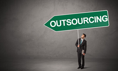 Obraz premium Young business person in casual holding road sign