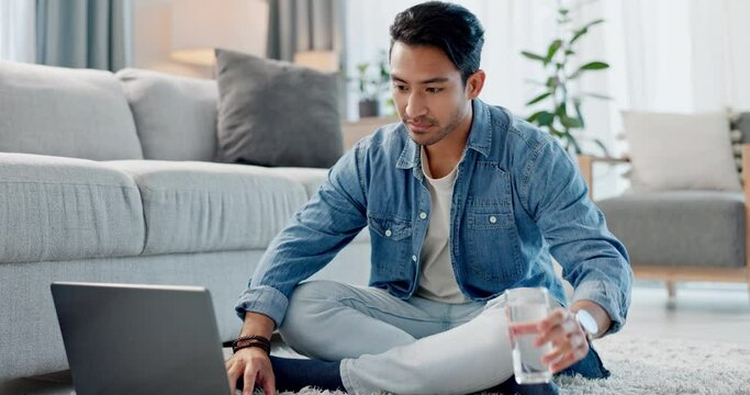 Home laptop, water and happy man typing, reading and check email communication, education blog and report study. Lounge floor, glass hydration drink or student learning online news, knowledge or info