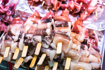 Group of raw octopus meat skewers which is prepared for seafood grilling meal. Seafood object photo, selective focus.