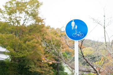 Road safety signpost of a parent need to take care a kid due to the bikeway. Transportation safety symbol object photo. 