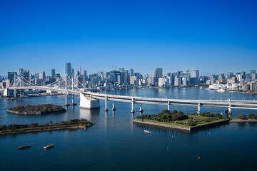Fototapeta premium View of Tokyo Skyline and Tokyo Bay with Rainbow Bridge on a clear blue sky day