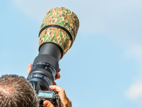 Telephoto lens oriented towards the sky photographing an air show or wildlife birds.
