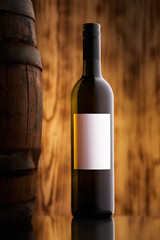White wine bottle next to barrel with white etiquette on dreamy vine back drop