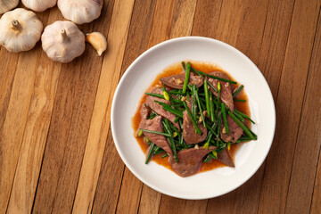 Stir fry flowering chinese chives with pork liver in white plate.Top view