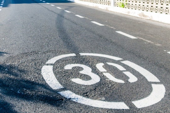 30kph/30mph speed limit painted on a road