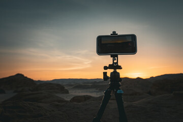 Smartphone on tripod in the desert shooting sunset Egypt - obrazy, fototapety, plakaty