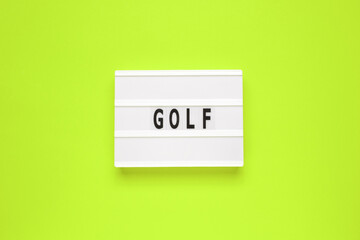 The word golf on lightbox isolated green background.