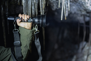 Naklejka premium A large powerful flashlight in a woman’s hand against the background of ruins, photo with weak lighting.