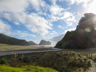 Evening light at Piha Beach with stream and Lion Rock on New Zealand's Tasman Sea coast