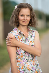 Fototapeta premium Beautiful young girl in a summer dress outdoors in the village.