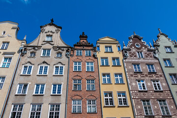 Fototapeta na wymiar Facade of row of colorful historical houses in the Old Town of Gdansk, Poland, set against a clear blue summer sky