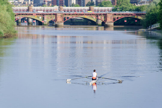 Man training on canoe to practise rowing during early morning on river