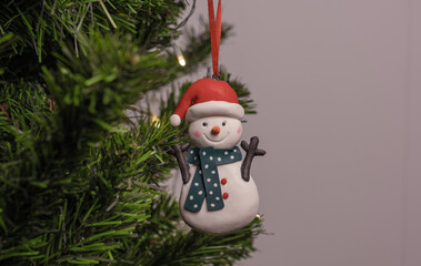 New Year's toy snowman hangs on the Christmas tree