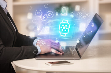 Hands working on laptop with digital icons