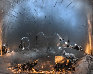 The texture of ice with frozen bubbles, backlit by artificial light.