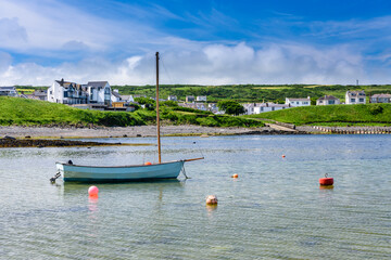 Small sailing boat with an outboard motor in Portbalintrae - obrazy, fototapety, plakaty