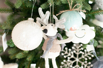 white plush reindeer and baubles tree ornaments festive background with copy space. Xmas tree...