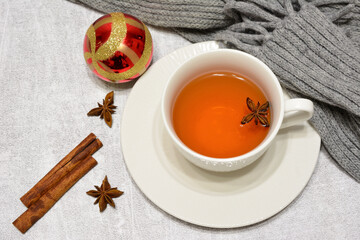 hot tea with cinnamon and badian decorated with scarf and red sphere 