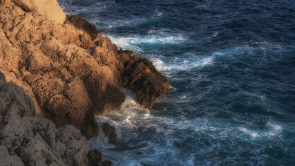 Waves beat against the coastal sea rock
