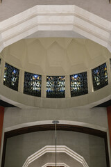 Fototapeta premium Art Deco interiors of Catholic minor basilica national shrine with massive dome and arch vaults, murals, altar and columns with Renaissance Revival style facade tourist pilgrim attraction