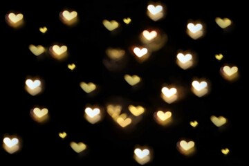 bokeh in the shape of a heart on a dark background.