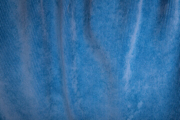 Crumpled blue velvet fabric used for sewing clothes for store. Textile material of velours texture as background. Catalog photo of samples. Grungy style.