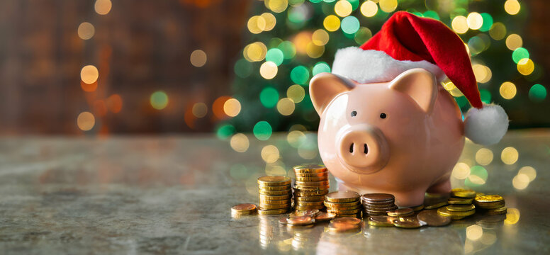 piggy bank with Christmas hat and coin stack on the table with Christmas background, saving, and financial concept with christmas celebration