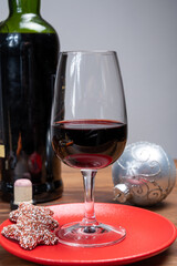 Popular british christmas drink, glass of vintage ruby port wine and christmas tree decoration