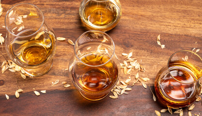 Tasting of different Scotch whiskies strong alcoholic drinks, drum of whiskey and colorful Scotch tartan on background close up