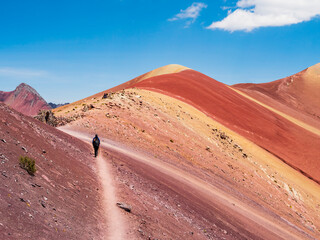 Tourists walking down the Red Valley (valle rojo) after visiting the Rainbow Mountain, Cusco region, Peru