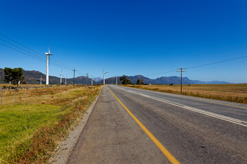 Wind turbines in an open field with blue skies near Porterville in the Western Cape, South Africa.