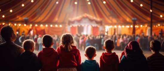 rear view kid children watching show on stage in circus carnival festive celebration in dome tent with crowd people inside exited lifestyle - obrazy, fototapety, plakaty