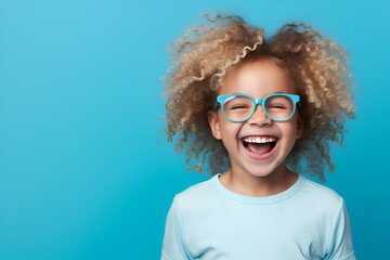 ortrait Of Funny Cute Little Girl in glasses Laughing At Camera, Posing Over blue Background In Studio, Free Space