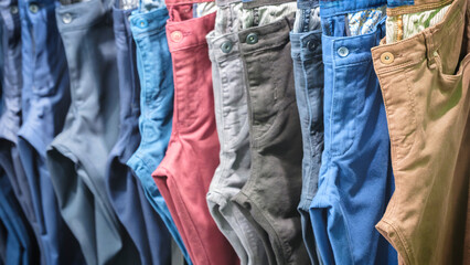 Many jeans hanging on arack. Row of pants denim jeans hanging in closet, concept of buy , sell ,...