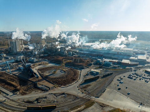 Aerial view of a large industrial complex, which is a paper mill. Smoke coming from the mill causing air pollution.