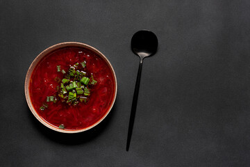 Traditional Ukrainian dish borsch on black stone table top view, copy space for your design.