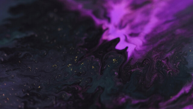 Paint drip. Ink water flow. Defocused glowing neon purple black golden color fluid wave motion particles texture dark art abstract background.