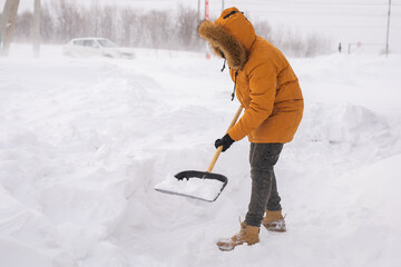 Man cleaning snow from sidewalk and using snow shovel. Winter season