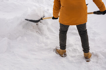 Man removing snow and ice from the sidewalk in front of house. Winter season