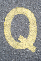 The Letter Q is drawn with color paint on asphalt. a children's playground designed a creative display of the alphabet educational element learning space.
