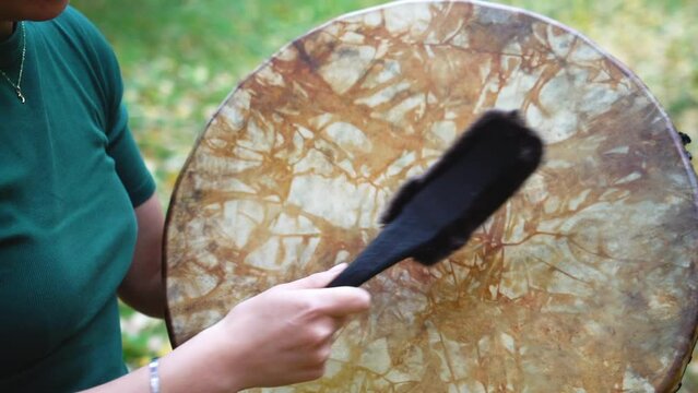A woman plays a shaman's tambourine. High quality FullHD footage
