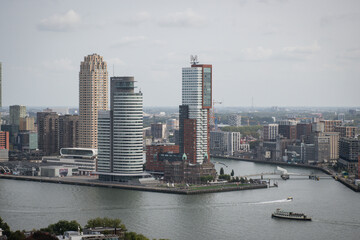 Fototapeta na wymiar Cosmopolitan famous Dutch city Rotterdam with skyscraper buildings and river Nieuwe Maas. Aerial daytime view of skyline in Holland