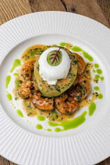 poached egg with avocado, tiger prawns and red caviar