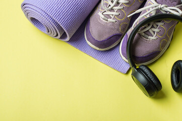 The concept of a healthy lifestyle, exercise, water balance, nutrition, regimen. Sports equipment on a bright yellow background, top view, horizontal, copy space.