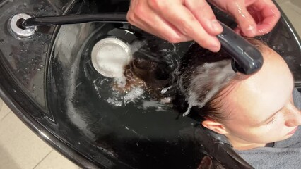 Hairdresser washing female customers hair, Close Up. High quality 4k footage