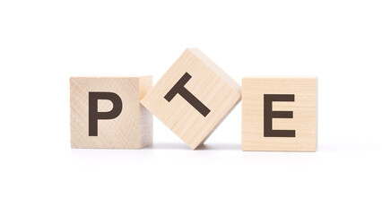 three wooden cubes with the letters PTE on white table. pearson tests of english concept