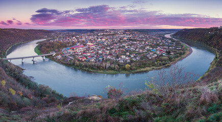 Panoramic view to the city around river with bridge before sunrise in Ukraine