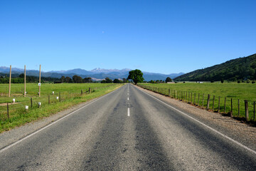 Straight and empty road in the countryside in NEw Zealand