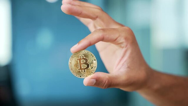 Close up of a man hand holding a gold bitcoin coin. Rich man holds and shows a gold coin. Cryptocurrency trading digital investments on Internet. Global blockchain technology Finance concept Closeup